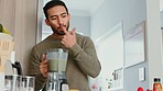 Health, energy and a breakfast smoothie with man nutritionist taste green drink in a kitchen. Fruit, diet and detox by happy male enjoy nutrition and fresh, spinach, kale and banana milkshake