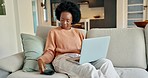 Black woman, laptop or phone in living room for communication, search or social media networking in house. Smile, happy or remote worker in house with kpi technology and smartphone or computer.
