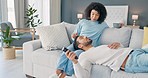 Black couple relax in home, on living room sofa and streaming tv online. Development in smartphone, tablet and pc tech innovation like 5g means people can view media anywhere in the house at a click 