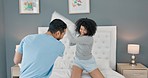 Love, pillow fight and couple with a man and woman playing on a bed in the bedroom of their home together. Freedom, fun and playful with a young male and female joking in the morning in their house