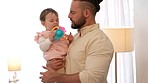 Father talking to newborn baby with toys for healthy growth, language learning and development. Happy, care and love with dad holding child in room or house for maternity and bonding together