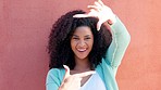 Happy black model, funny frame face on wall background and portrait smile in sunshine. Young african woman laugh at zoom focus gesture, ready for closeup and crazy creative photography idea with afro
