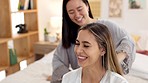 Friends, brush hair and women in bedroom get ready for bed, girls night out or special event. Happy, smile and girlfriends grooming at sleepover at home. Asian girl and friend talk in pajamas on bed.