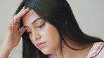 Stress, headache and burnout with a woman suffering with anxiety, worry or a migraine while rubbing her head with her hand. Mental health, sad and frustrated with a young female feeling depressed