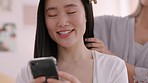 Wedding, phone and brushing hair with a bride talking and laughing with her bridesmaid before a marriage ceremony. Romance, love and streaming with a young woman getting ready for a celebration event