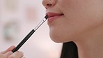 Cosmetics, lipstick and lips of woman doing her makeup while preparing for event in room. Cosmetology, beauty and closeup of girl doing luxury glamour, pamper or cosmetic mouth treatment with brush.