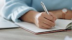 Hands, writing and book of woman with a pen in study journal, diary or notebook at home. Hand of a creative female writer on paper plan, idea or reminder for business goals on table or desk