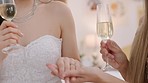 Bride showing her wedding ring to her friend before her wedding. Bridesmaid looking at engagement ring on hand of woman getting married, drinking champagne and getting ready for wedding ceremony