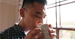 Man drink coffee in peace, home comfort and break to rest, relax and enjoy morning. Asian person sipping warm, fresh and hot tea beverage in thinking mindset, calm face and inspiration at room window