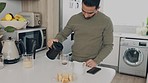 Man at table in kitchen make coffee for energy, to start the day or morning in his home or apartment. Male in house pour hot beverage into mug, to drink at breakfast for healthy and focused mind