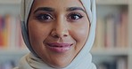 Muslim arab woman face, portrait and smile from Saudi Arabia wearing traditional headscarf, hijab and islamic religion. Happy, holy and young arabic student studying, learning and university library