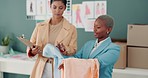 Startup, fashion design and retail business women with fabric. Black women with a clipboard look at clothing, stock and fashion products in studio for ecommerce, delivery and sales in supplier store