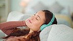 Woman headphones, listening to relax music, podcast and smile with a calm, zen and peaceful day at home. Happy Asian female and relaxed woman sitting on a living room sofa and meditation with audio