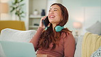 Woman talk on smartphone, relax on sofa and laughing with friends on call while working on laptop from home. Employee on couch, living room and using headphones to listen to podcast or music to focus