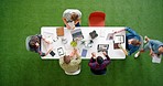 Top view, business people and digital marketing meeting with documents, technology or paper on modern office grass turf. Men, women and creative designers with web design planning on laptop or tablet