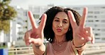 Black woman, smile and hands peace sign in city, street or outdoors. Happy, travel and cool female from South Africa showing victory hand gesture, having fun and spending quality time alone in town.