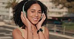Black woman, headphones and listening to music in the city for happy dance, travel and fun in the outdoors. African American female enjoying audio dancing, good vibes and chilling in a urban town
