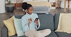 Mobile, good news and happy black woman on a home living room couch reading a text. Dating app, internet and web scroll of a person from New York on a house lounge sofa using technology online