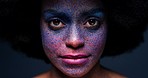 Beauty, paint and face portrait of a black woman with an afro standing in studio with art expression. Color splash, colorful and creative face makeup of model for empowerment, creativity and freedom.