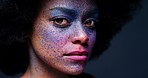 Color face paint makeup, black woman portrait and abstract, creative art and fantasy cosmetics on dark studio background. Afro artist model, splash beauty and mystery of bold rainbow design on skin