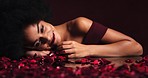 Roses, beauty and portrait of a black model with a smile in a studio with a dark background. Happy, beautiful and sensual african woman with romantic red blossom flowers for valentines day.