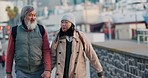 Chinese couple, senior tourist and city travel while holding hands, talking and walking to subway for sightseeing tour in urban town. Happy man and woman traveling in cold weather on downtown street