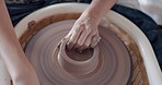 Pottery, art and hands on a potter wheel with artist spinning clay in creative class, workshop or studio. Creativity, handicraft and closeup of a sculptor working on ceramic design, craft or creation