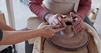 Hands, pottery and clay with a man student learning from a female potter in the studio or ceramic workshop. Art, creative and sculpting with a woman teacher with a male artisan during a lesson