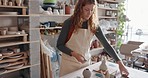 Pottery, sculpture and small business owner woman in her startup retail shop or workshop studio for product design process. Young creativity designer entrepreneur artist with clay production career