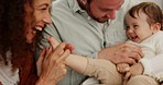 Happy, love and parents playing with their baby with care in the living room of their family home. Mom, dad and child being playful together with happiness, laughing and bonding in lounge of a house.