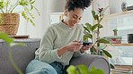 Online in living room, black woman playing game on smartphone and mobile entertainment in Chicago home. Young girl typing on cellphone, excited celebration with fun app on sofa and competition winner