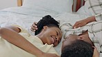 Black couple, love and communication, touching and happy together, conversation and bonding while in bedroom at home. Black woman, black man lying on bed, care and trust, connection and talking.