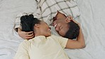 Couple, black woman and kiss on bed together with love, romance and bonding while happy in home. Man, girl and smile with happiness, care and embrace for black couple in bedroom lying with intimacy