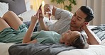 Phone, social media and communication with a couple in bed in the morning to relax together in their home. Mobile, internet and bedroom with a man and woman relaxing in their house on the weekend