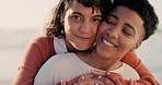 Couple, lgbt and lesbian women at the beach hugging, embrace and holding each other. Love, romance and   portrait of lesbian couple enjoying sunset, holiday and summer by the ocean with smile on face