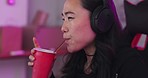 Asian, woman and gamer at computer eating and drinking with focus for game, competition or contest in home. Girl, happy and soda in room for esports, online gaming and tech for video game on web