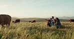 Cattle, cow and farmer with family on a farm bonding, relaxing and enjoying quality time on countryside grass field. Nature, mother and father pointing to animals or cows with his girl, kid or child