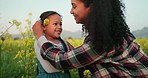 Love, mother and child in flowers field for family bonding moment together in Mexico nature. Happy, care and smile of Mexican mom picking wild plants with daughter in beautiful landscape.

