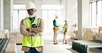 Construction, leadership and engineer with a black man architect standing on a building site with his arms crossed. Architecture, design and manager with a mature male supervisor and his team
