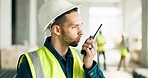 Logistics, construction and architect talking on a walkie talkie while working as a construction worker at a site. Man in architecture in communication on tech while doing a building project