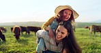 Family, farm and fun with a girl and mother playing on a grass meadow or field with cattle in the background. Agriculture, sustainability and love with a woman and her daughter enjoying time together