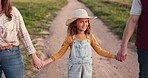 Family, farm and agriculture with a girl holding hands with her parents on a sand road in a field or meadow. Sustainability, love and summer with a daughter hand in hand with her mother and father