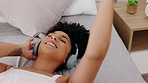 Black woman, headphones and on bed listen to music, online streaming and dance being happy, smile and at home. Young female, girl and with wireless headset being joyful, cheerful or enjoy radio audio