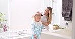 Hair care, mother and girl in bathroom, with brush and bonding to connect, talking and for fun. Female, lady and daughter or kid doing development, child growth and discussion together at home loving