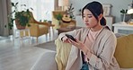 Phone, living room and woman from China with mobile technology and social media scroll at home. Web, internet and online digital texting of a person using a mobile phone in a house lounge sofa 