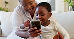 Social media, mother and child with a phone on the sofa for learning, education and communication in their house. Happy, smile and African baby and mom reading a chat on a mobile app on the couch