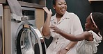 Mother, child and laundry with high five for teamwork, help and support working together for chores at home. Happy African American mom and helpful kid folding clothes in basket celebrating success