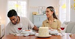 Interracial, couple and celebrate for birthday with gift, being happy and relax together at party. Romance, man and woman with present, bonding and smile in home in living room for hug and embrace.