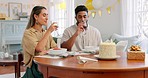 Happy, birthday and toast with couple at table for party celebration with wine, food and cake. Anniversary, event and love with man and woman with glass cheers in living room for gift, smile and date