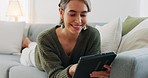 Woman, smile and lying of sofa with tablet for social media, communication or app in living room. Girl, happy or technology on internet, web or social network on couch to relax with happiness in home